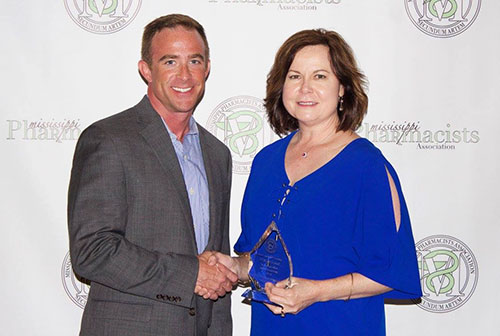 Terry Kirby, director of Pharmacy for the Mississippi Division of Medicaid, accepts the 2017 Spirit of Pharmacy Award from Peter Stokes, executive director of the Mississippi Pharmacists Association.